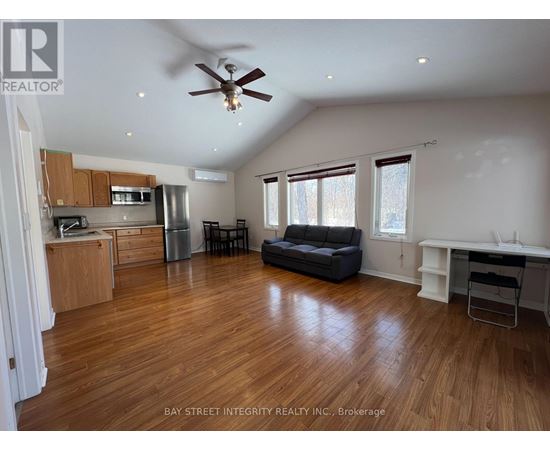A spacious living room with wood flooring and a ceiling fan.