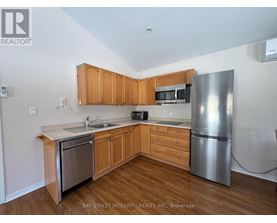 A kitchen with wooden cabinets and a stainless steel refrigerator.