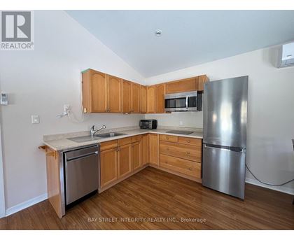 A kitchen with wooden cabinets and a stainless steel refrigerator.