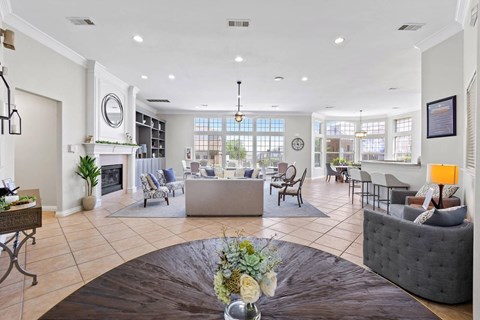 A living room with a grey couch and a coffee table with flowers on it.
