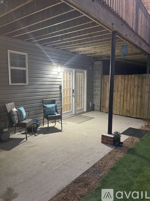 A patio with a chair and a table with a blue pillow.