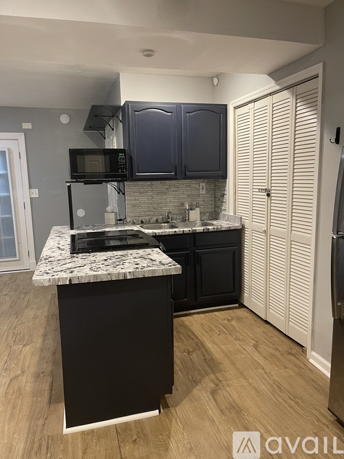 A kitchen with black cabinets and a white countertop.