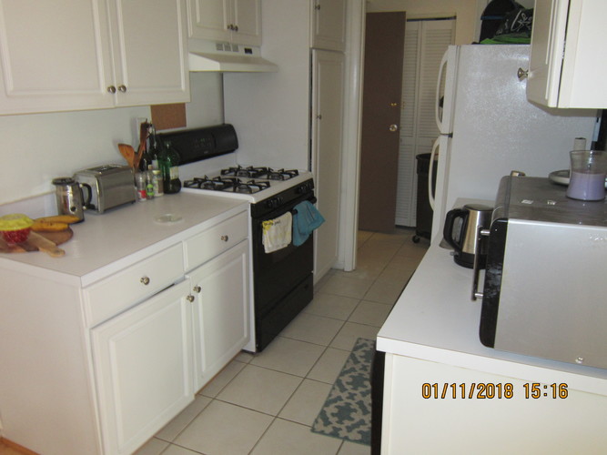 A kitchen with a white fridge and black stove.