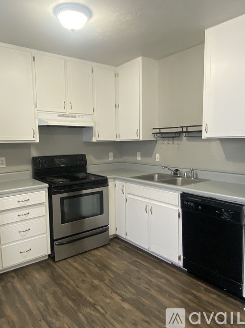 A kitchen with white cabinets and a black stove top oven.