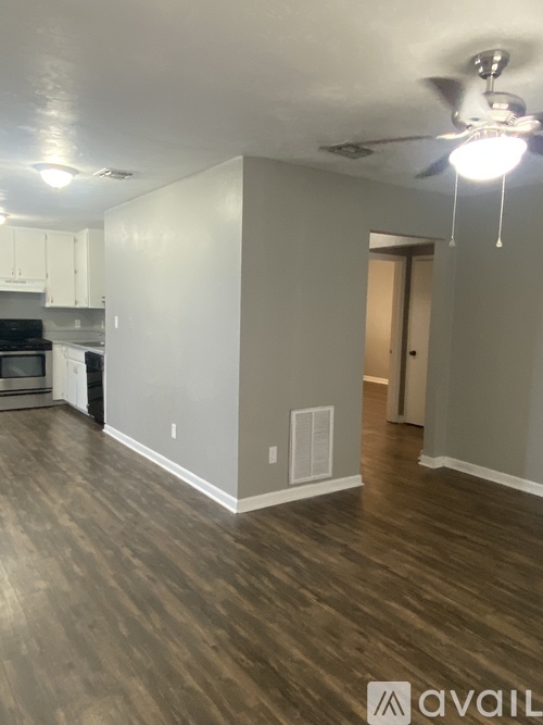 A room with a ceiling fan and wooden flooring.