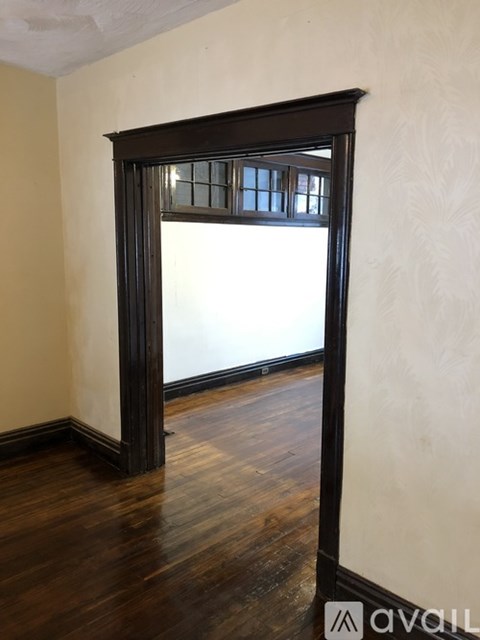 A room with a large wooden door and a window.