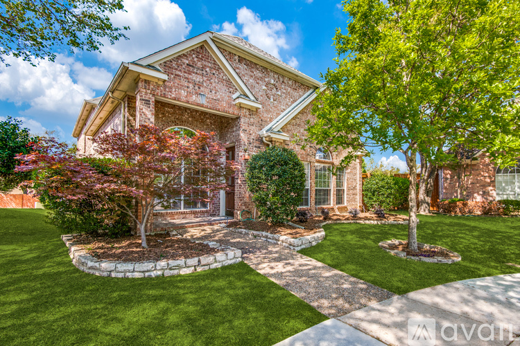 A house with a well-manicured lawn and a stone pathway leading to the front door.