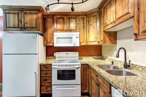 A kitchen with wooden cabinets and a white refrigerator.