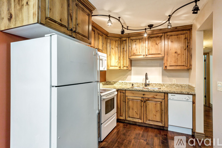 A kitchen with wooden cabinets and a white refrigerator.