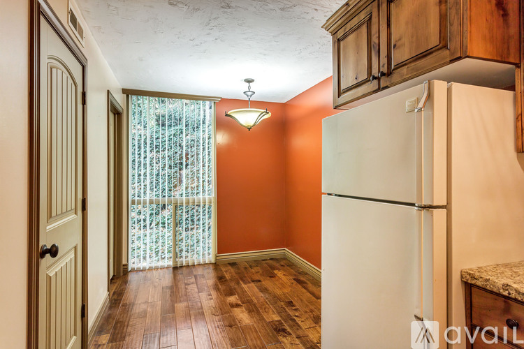 A kitchen with a white refrigerator and wooden cabinets.