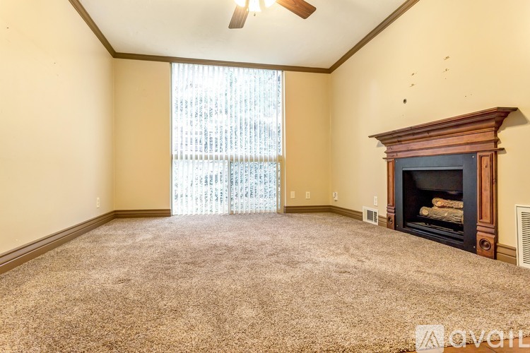 A living room with a fireplace and a ceiling fan.