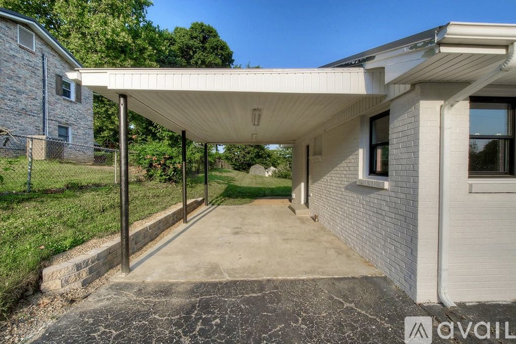 A covered walkway leads from a house to a driveway.