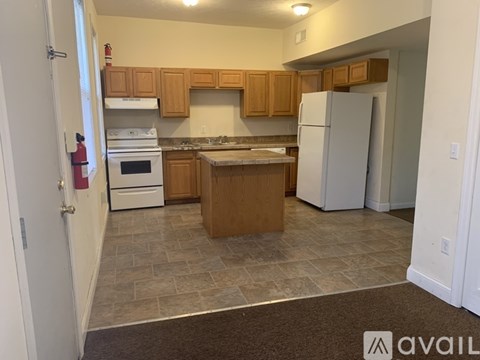 A kitchen with wooden cabinets and a white refrigerator.