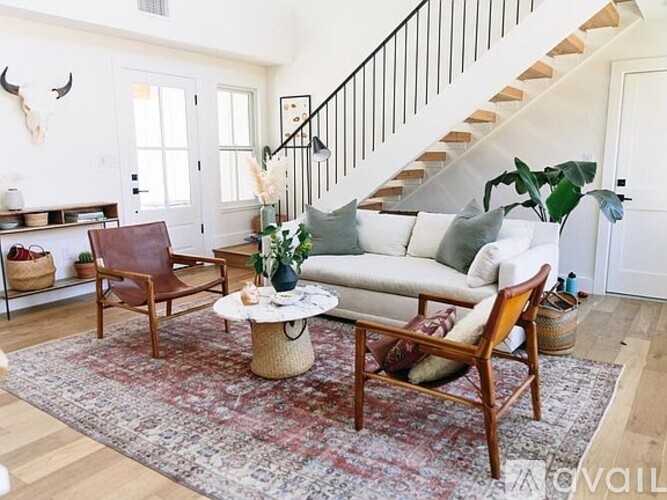 A living room with a white couch, a wooden coffee table, and a rug.