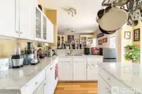 A kitchen with white cabinets and a white countertop.