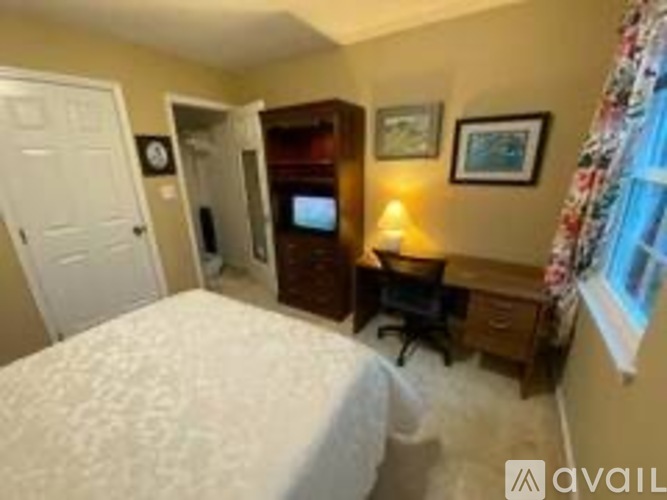 A bedroom with a bed, desk, and chair.