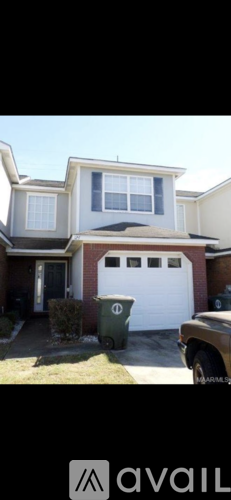A two-story house with a white garage door and a brown roof.