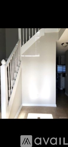 A hallway with a white railing and a light on the wall.
