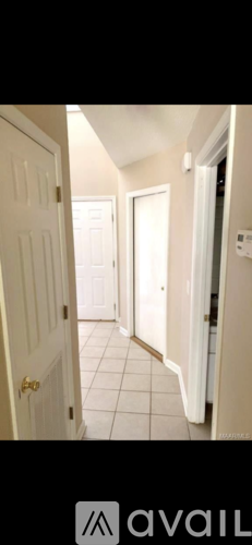 A hallway with white doors and tiled floors.