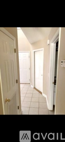 A hallway with white doors and tiled floors.