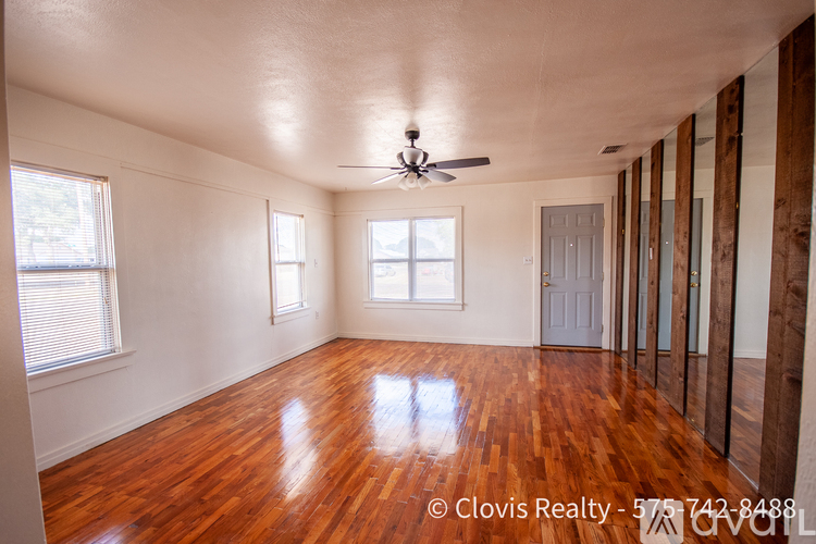 A room with wooden floors and a ceiling fan.
