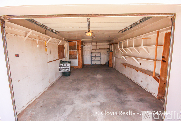 A large, empty garage with a sign that says "POOL BENT".