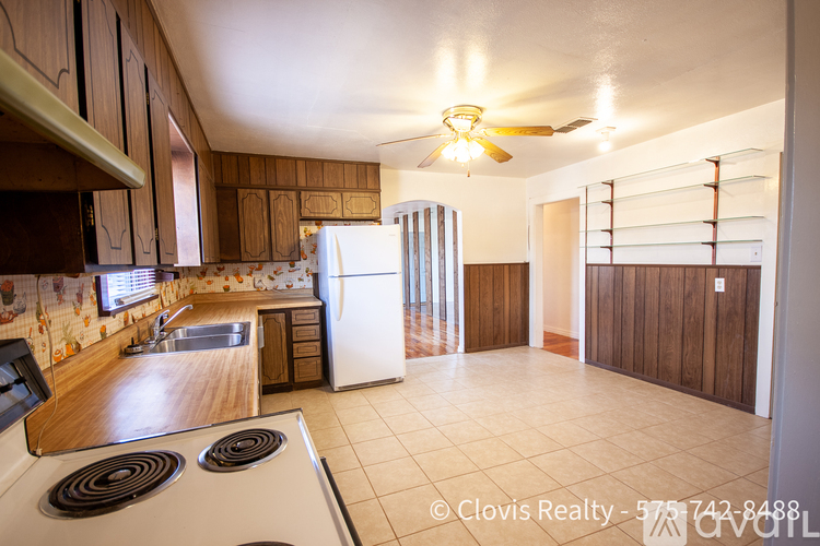 A kitchen with a white stove top oven and a white refrigerator.