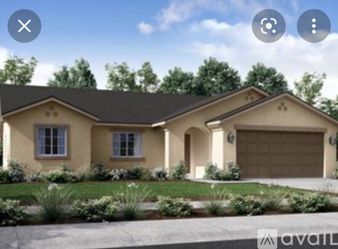 A beige house with a brown roof and a garage door.