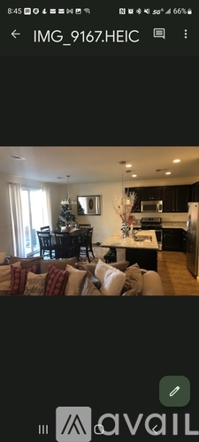 A living room with a Christmas tree and a dining area.