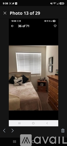 A bedroom with a bed, nightstand, and window with blinds.