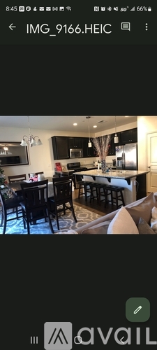 A modern kitchen with black cabinets and a dining table set for four.