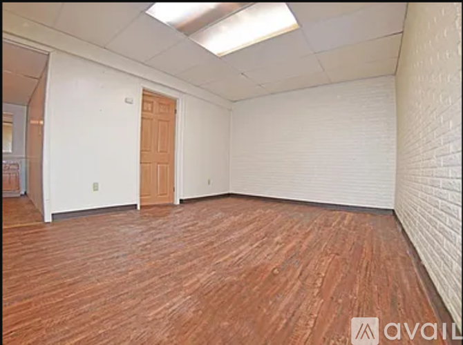 A room with wooden flooring and a closed door.