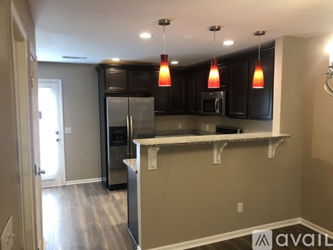 A kitchen with a refrigerator, microwave, and oven.