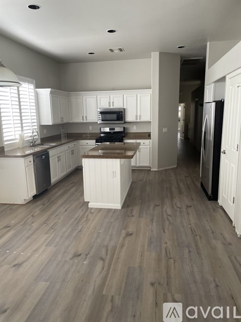 A kitchen with white cabinets and a wooden floor.
