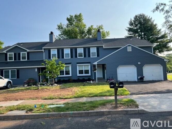 A house with a grey exterior and a white car parked in front.