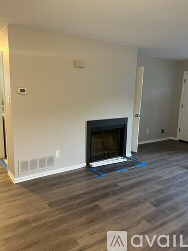 A living room with a fireplace and wooden flooring.