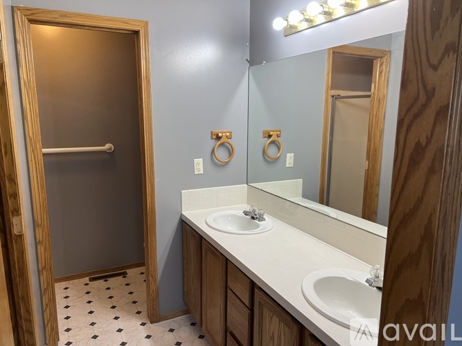 A bathroom with a sink, mirror, and towel rack.