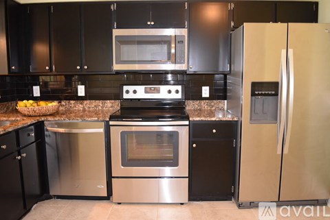 A kitchen with black cabinets and stainless steel appliances.