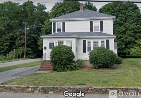 A white house with a grey roof and a small porch.