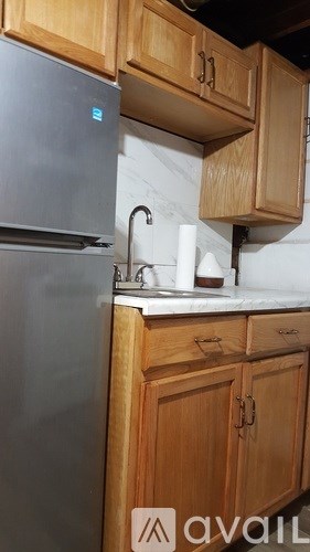 A kitchen with wooden cabinets and a stainless steel refrigerator.