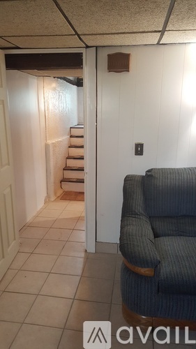 A living room with a couch and a staircase.