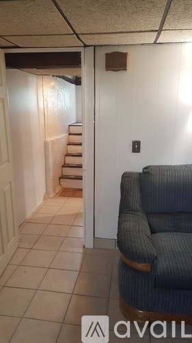 A living room with a couch and a staircase.