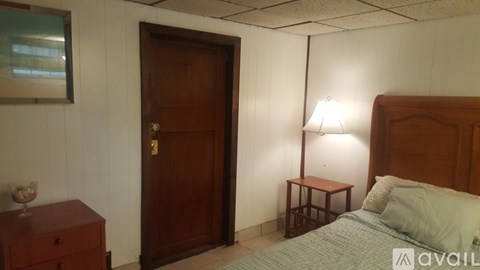 A bedroom with a bed, nightstand, and lamp.