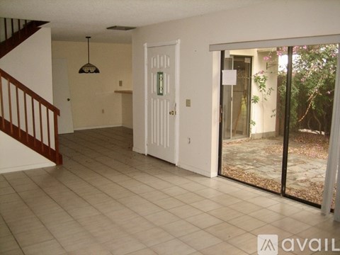 A room with a white door and a chandelier hanging from the ceiling.