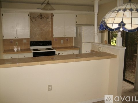 A kitchen with a stove top oven and a tiled backsplash.