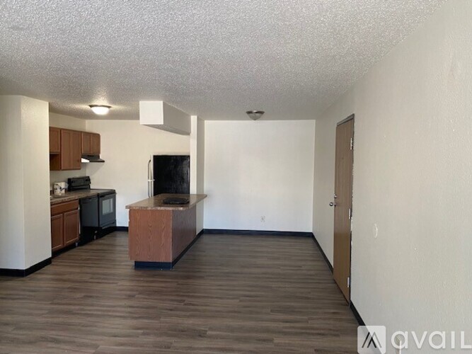 A living room with a wooden floor and a television.