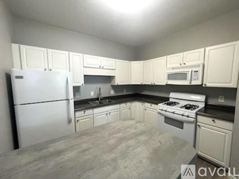 A kitchen with white cabinets and appliances.