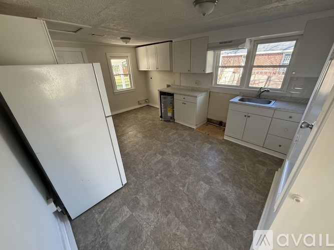 A kitchen with a white refrigerator and cabinets.