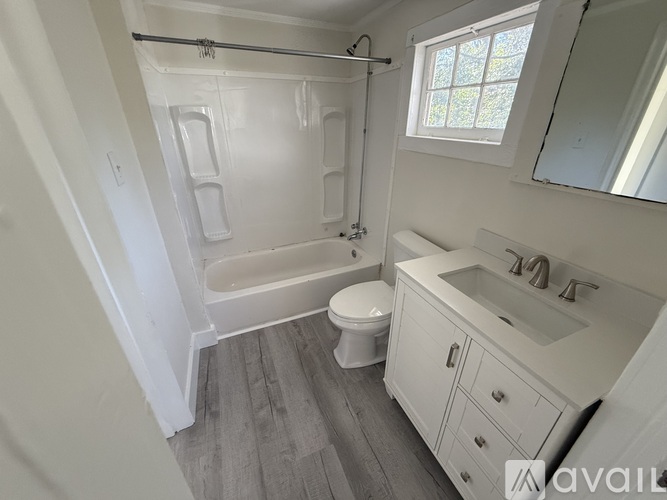 A bathroom with a toilet, sink, and bathtub.