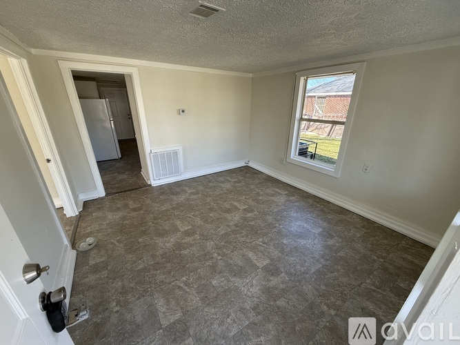A room with a tiled floor and a window showing a view of a building outside.